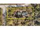 An aerial view of a wooded property featuring mature trees surrounding the home and a lengthy driveway at 7157 Knoxville Dr, Webster, FL 33597