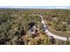 Aerial view of home nestled amongst towering trees with easy road access at 7157 Knoxville Dr, Webster, FL 33597