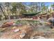 Relaxing backyard pond and garden area with mature trees and shaded seating at 7157 Knoxville Dr, Webster, FL 33597