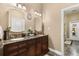 Bathroom with double sink vanity, granite counters, and dark wood cabinets at 7157 Knoxville Dr, Webster, FL 33597