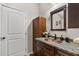 Bathroom featuring dark wood cabinetry, a copper sink, and granite countertops at 7157 Knoxville Dr, Webster, FL 33597