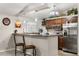 Kitchen featuring a bar with pendant lights, stainless steel appliances, and wooden cabinets at 7157 Knoxville Dr, Webster, FL 33597