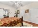 Spacious bedroom with hardwood floors, a sliding barn door to an office space, and plenty of natural light at 7157 Knoxville Dr, Webster, FL 33597