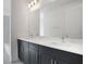 Modern bathroom features double sinks with dark cabinetry and a large mirror at 196 Eagleston Ln, Lakewood Ranch, FL 34240