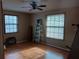 Standard bedroom featuring a ceiling fan, two windows, and laminate wood flooring at 25327 Celmar St, Brooksville, FL 34601