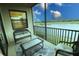 Private screened balcony overlooking serene lake with comfortable seating for relaxation at 7005 River Hammock Dr # 207, Bradenton, FL 34212
