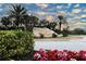 Community entrance with lush landscaping, colorful flowers, and a rock feature at 7005 River Hammock Dr # 207, Bradenton, FL 34212