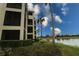 Exterior view of building with screened balconies overlooking a scenic lake and lush greenery at 7005 River Hammock Dr # 207, Bradenton, FL 34212