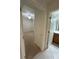Hallway view of a bedroom with a ceiling fan next to a bathroom featuring a wood vanity at 7005 River Hammock Dr # 207, Bradenton, FL 34212