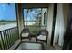 Relaxing screened patio with outdoor furniture overlooking a tranquil lake and swaying palm trees at 7005 River Hammock Dr # 207, Bradenton, FL 34212