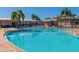 Resort-style pool area with lounge chairs, umbrellas, and inviting blue water at 7005 River Hammock Dr # 207, Bradenton, FL 34212