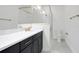 Bright bathroom featuring a glass shower, black cabinets and white marble tile flooring at 9015 Rothman Ln, Lakewood Ranch, FL 34240