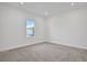 Well-lit bedroom with gray carpet, white walls, and a large window at 9015 Rothman Ln, Lakewood Ranch, FL 34240