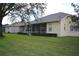A large backyard with lush green grass and a screened in patio at 13550 Thoroughbred Dr, Dade City, FL 33525