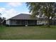 Expansive backyard featuring a screened-in lanai and mature landscaping, perfect for outdoor relaxation and entertainment at 13550 Thoroughbred Dr, Dade City, FL 33525