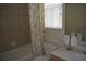 Cozy bathroom features a tub/shower combo with floral curtain, and a vanity with a sink and towel rack at 13550 Thoroughbred Dr, Dade City, FL 33525