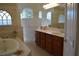 A luxurious bathroom featuring a soaking tub, tiled walls and dual sinks, providing a spa-like experience at 13550 Thoroughbred Dr, Dade City, FL 33525