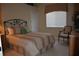 Cozy bedroom featuring a decorative wrought iron headboard, comfortable bedding, and a neutral color palette at 13550 Thoroughbred Dr, Dade City, FL 33525