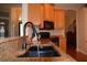 Close-up of the kitchen sink with granite countertops, black appliances, and wooden cabinetry at 13550 Thoroughbred Dr, Dade City, FL 33525