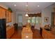 Bright kitchen featuring wood cabinets, granite countertops, and modern appliances with a dining area beyond at 13550 Thoroughbred Dr, Dade City, FL 33525