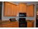 Charming kitchen with granite countertops, wood cabinets and black appliances at 13550 Thoroughbred Dr, Dade City, FL 33525