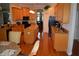 Well-lit kitchen features wood cabinets, granite countertops, an island, and black appliances at 13550 Thoroughbred Dr, Dade City, FL 33525
