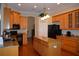 Spacious kitchen with wood cabinets, granite countertops, hardwood floors, and stainless appliances at 13550 Thoroughbred Dr, Dade City, FL 33525
