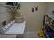 Functional laundry room with a washer, dryer, basket, shelving, and wall decorations for added charm at 13550 Thoroughbred Dr, Dade City, FL 33525