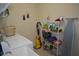 Practical laundry room includes a washer, dryer, sink, ironing board, shelving, and playful wall art at 13550 Thoroughbred Dr, Dade City, FL 33525