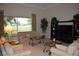 Bright living room with stylish furnishings, including sofas, armchairs, and decorative tables facing the green backyard at 13550 Thoroughbred Dr, Dade City, FL 33525