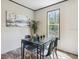 Bright dining area with a glass table, black chairs, large window, and nature-themed painting on the wall at 9471 Adler St, New Port Richey, FL 34654