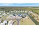 Aerial view of the community center, lake, trees, and homes in the surrounding neighborhood at 8461 Buttonquail Dr, Englewood, FL 34224