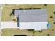 Aerial view of roof of home and the paved driveway surrounded by green grass and some palm trees at 8461 Buttonquail Dr, Englewood, FL 34224