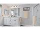 Bright bathroom features a double vanity, neutral walls, and a shower with glass doors at 8461 Buttonquail Dr, Englewood, FL 34224