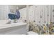 Well-lit bathroom with white countertop, vanity, and floral shower curtain at 8461 Buttonquail Dr, Englewood, FL 34224