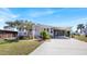 Inviting single-story home with a covered porch, a small American flag, and lush landscaping at 8461 Buttonquail Dr, Englewood, FL 34224
