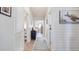 Bright hallway with plank walls leading to bedrooms and laundry, creating a welcoming path at 8461 Buttonquail Dr, Englewood, FL 34224