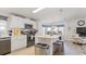 Well-lit kitchen featuring white cabinets, stainless steel appliances, and an island with bar stool seating at 8461 Buttonquail Dr, Englewood, FL 34224