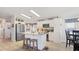 Bright kitchen with white cabinets, stainless appliances, kitchen island, and adjacent dining area with lots of light at 8461 Buttonquail Dr, Englewood, FL 34224