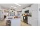 Bright, open kitchen with kitchen island, stainless steel appliances, and white cabinetry with a full pantry at 8461 Buttonquail Dr, Englewood, FL 34224