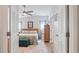 Bright bedroom features a ceiling fan, neutral walls, and a cushioned bench at the foot of the bed at 8461 Buttonquail Dr, Englewood, FL 34224