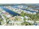 Aerial view of waterfront neighborhood with canal access, lush greenery, and well-maintained homes at 3427 Minnow Creek Dr, Hernando Beach, FL 34607