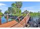 Wooden dock overlooking canal and the light-yellow house in the distance at 3427 Minnow Creek Dr, Hernando Beach, FL 34607