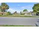 Charming single story home with an attached garage surrounded by mature palm trees and green lawn at 3427 Minnow Creek Dr, Hernando Beach, FL 34607