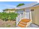 A closer view of a light-yellow house entrance with a well-kept garden and a white door at 3427 Minnow Creek Dr, Hernando Beach, FL 34607