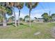 Spacious front yard with mature palm trees, showcasing the home's curb appeal and outdoor potential at 3427 Minnow Creek Dr, Hernando Beach, FL 34607