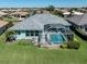 Aerial view of a backyard featuring a screened pool and lush green lawn at 519 Purslane Pt, Venice, FL 34293