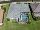 Aerial view of a backyard featuring a screened-in pool and beautifully maintained lawn at 519 Purslane Pt, Venice, FL 34293
