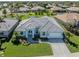 Aerial view showcasing a well-maintained home, mature trees and an expansive green lawn at 519 Purslane Pt, Venice, FL 34293