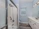 Bathroom with a walk-in shower and a white dual vanity illuminated by a bright window at 519 Purslane Pt, Venice, FL 34293